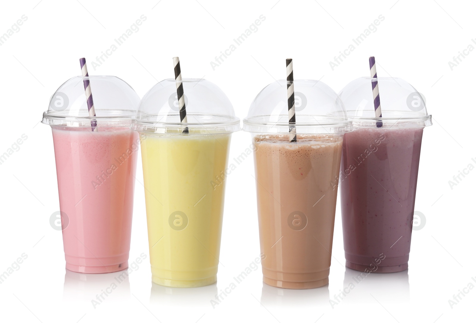Photo of Milkshakes of different flavors in plastic cups isolated on white