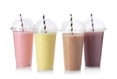 Photo of Milkshakes of different flavors in plastic cups isolated on white