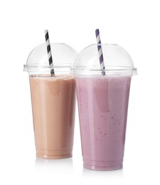 Photo of Milkshakes of different flavors in plastic cups isolated on white