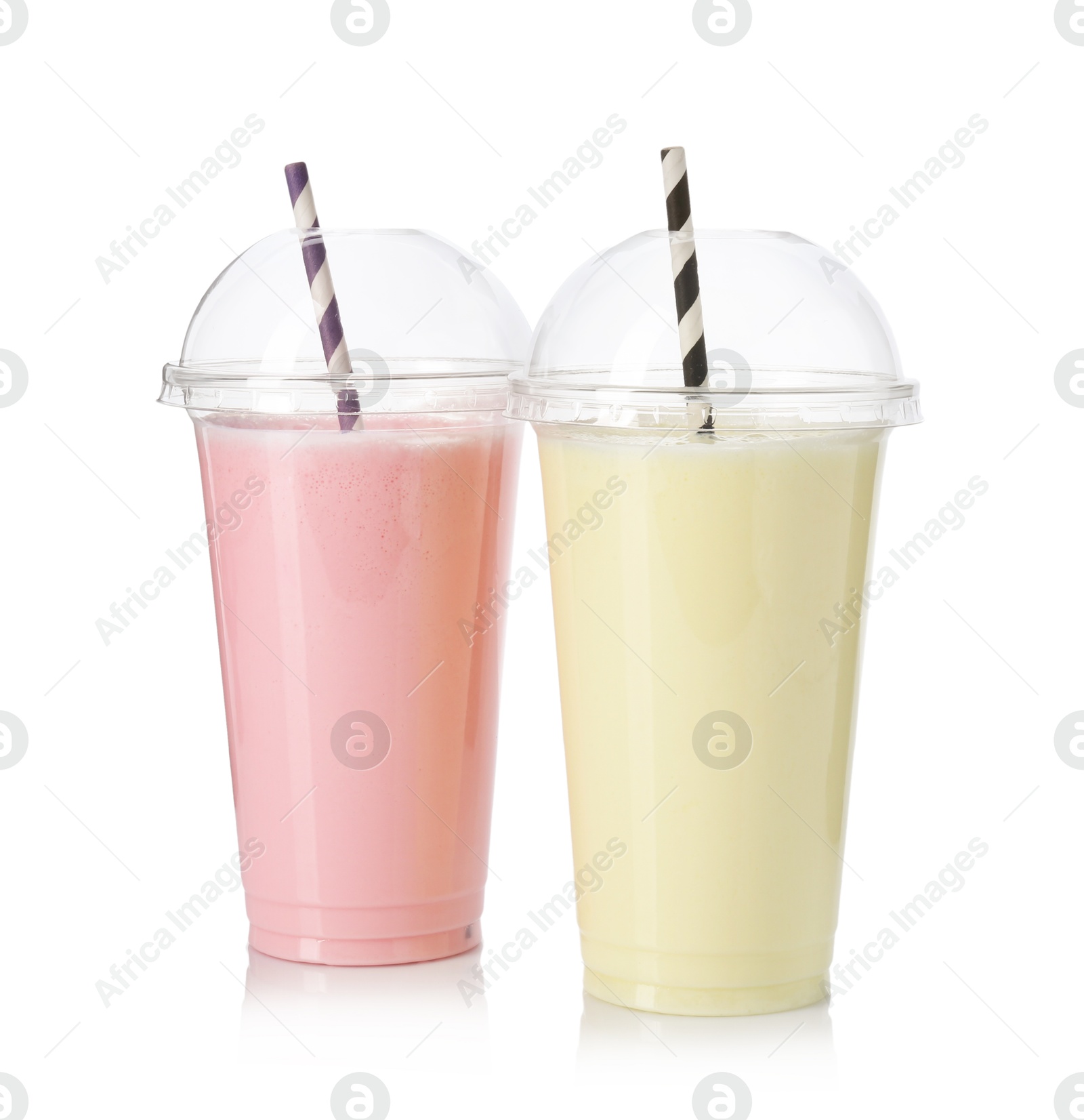 Photo of Milkshakes of different flavors in plastic cups isolated on white