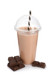 Photo of Tasty milkshake in plastic cup and chocolate pieces isolated on white