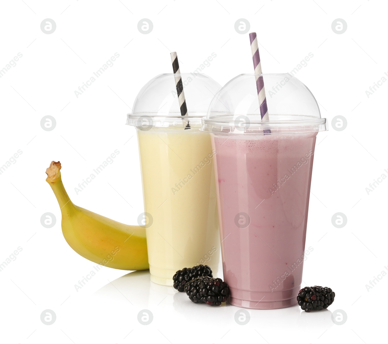 Photo of Milkshakes of different flavors in plastic cups and ingredients isolated on white