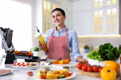 Photo of Woman cooking vegetables and meat on electric grill in kitchen