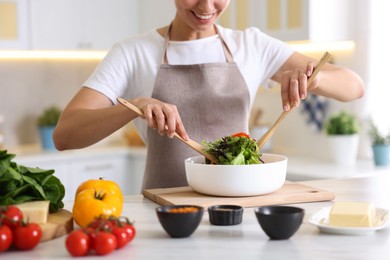 Photo of Smiling woman cooking at table in kitchen, closeup