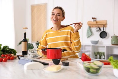 Photo of Smiling woman cooking at table in kitchen