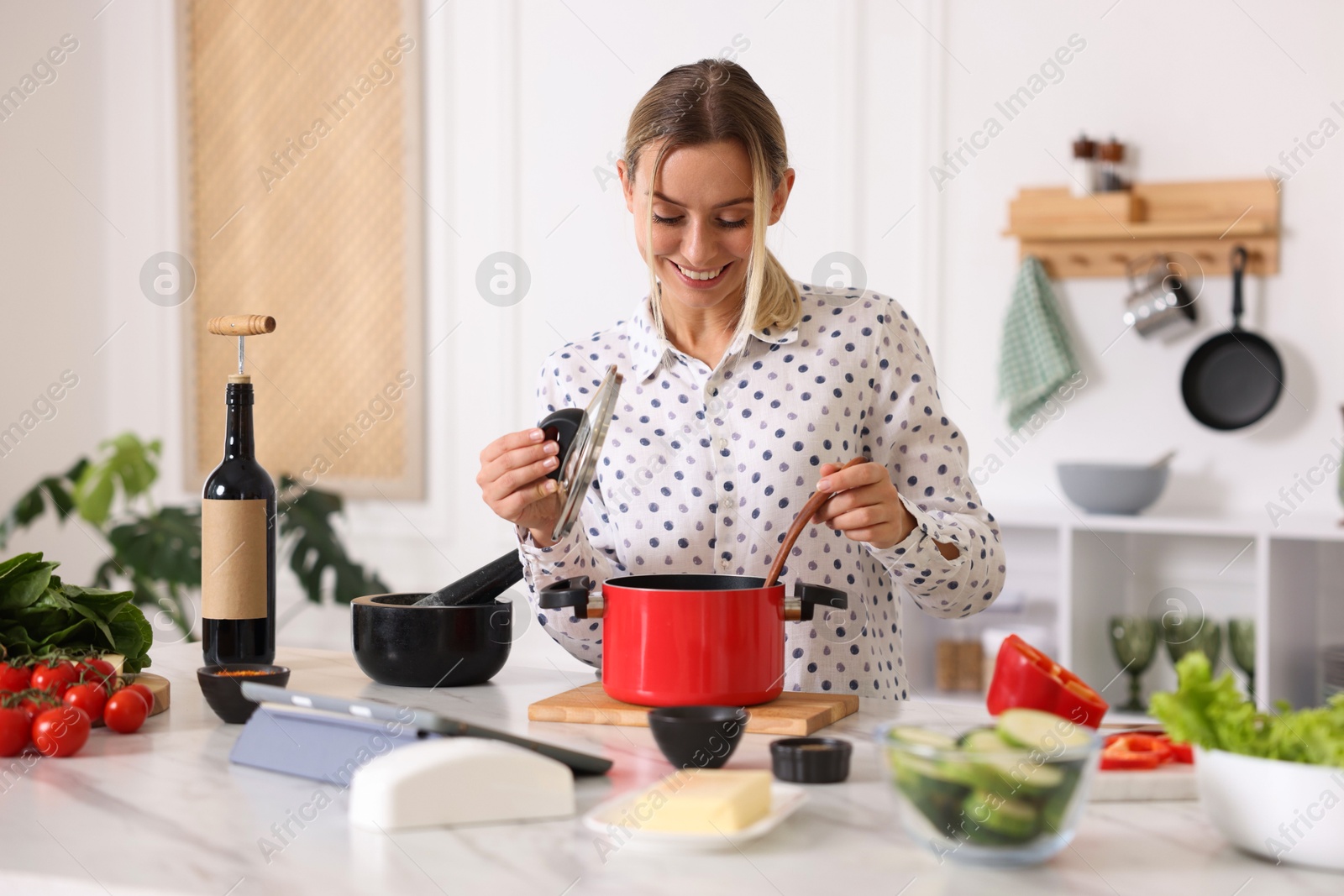 Photo of Smiling woman cooking at table in kitchen