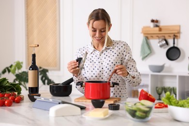 Photo of Smiling woman cooking at table in kitchen