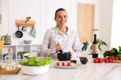 Photo of Smiling woman cooking at table in kitchen