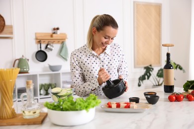 Photo of Smiling woman cooking at table in kitchen