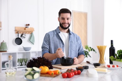 Photo of Smiling man cooking at table in kitchen