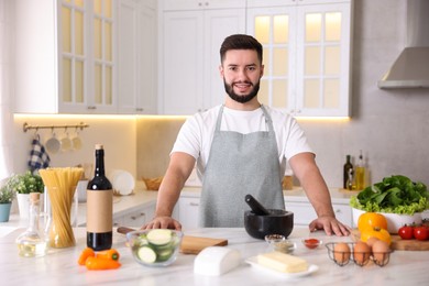 Photo of Smiling man cooking at table in kitchen