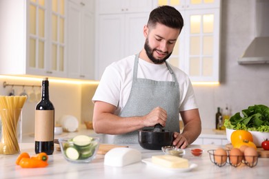 Photo of Smiling man cooking at table in kitchen
