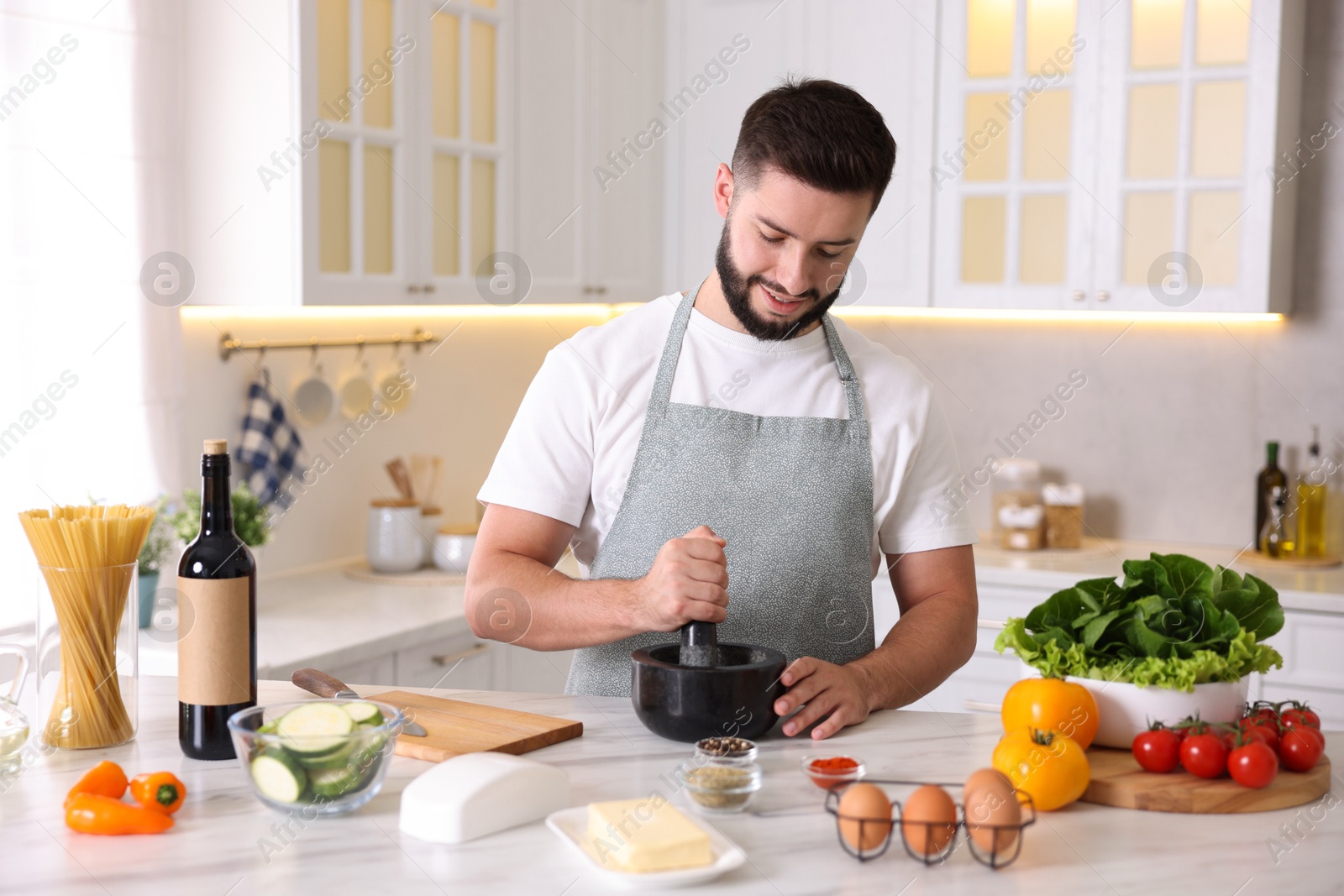 Photo of Smiling man cooking at table in kitchen