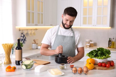 Photo of Smiling man cooking at table in kitchen