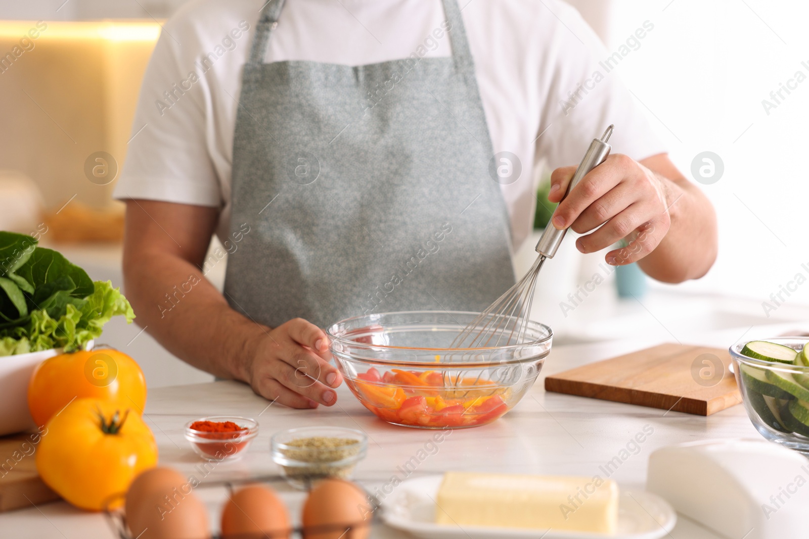 Photo of Man with whisk cooking at table indoors, closeup