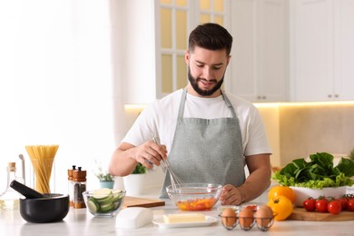 Photo of Smiling man cooking at table in kitchen