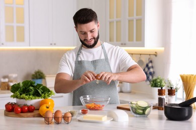 Photo of Smiling man cooking at table in kitchen