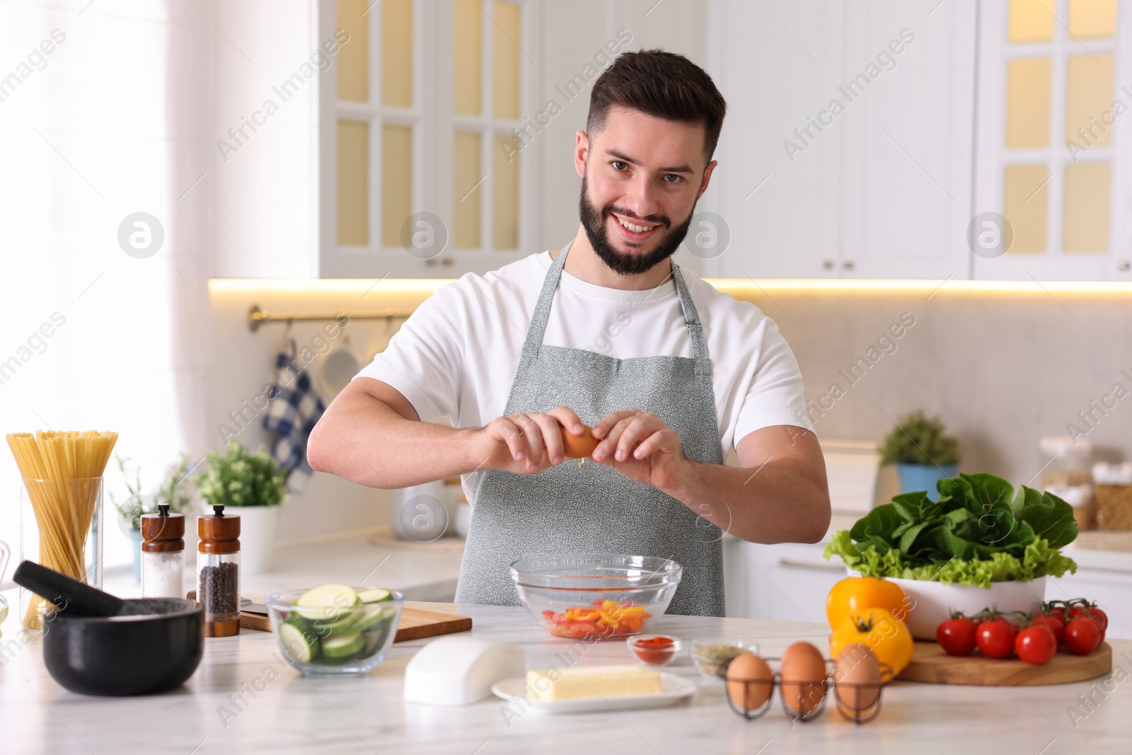 Photo of Smiling man cooking at table in kitchen