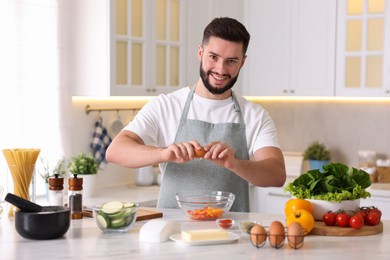 Photo of Smiling man cooking at table in kitchen