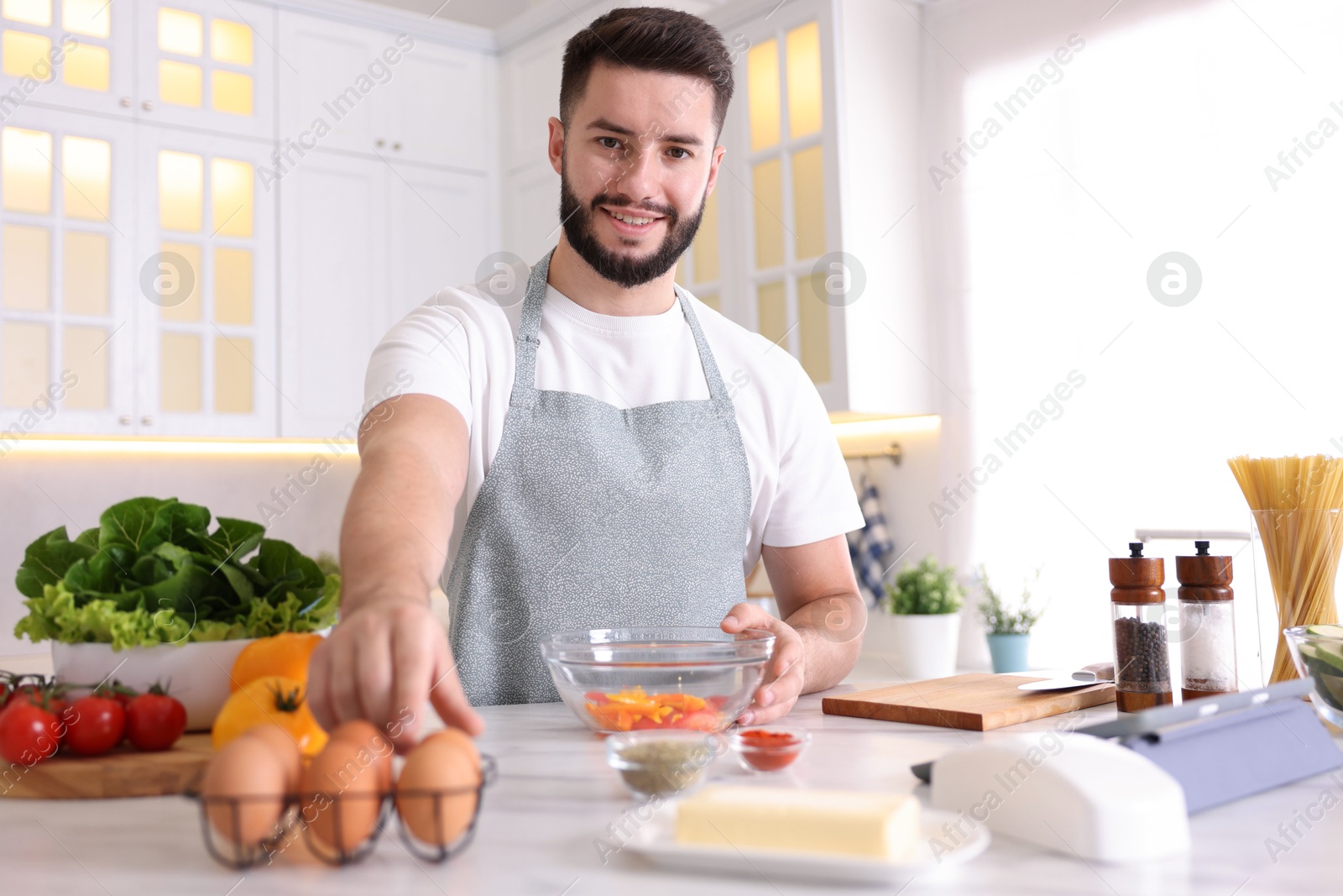 Photo of Smiling man cooking at table in kitchen