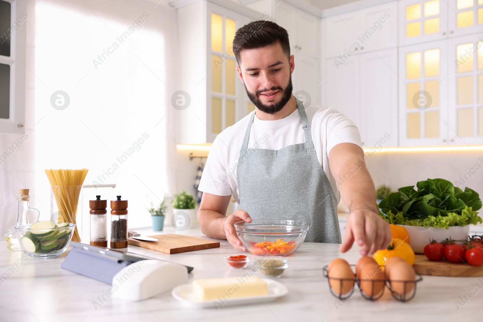 Photo of Smiling man cooking at table in kitchen