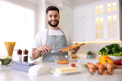 Photo of Smiling man cooking at table in kitchen