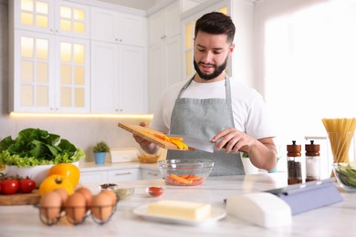 Photo of Smiling man cooking at table in kitchen