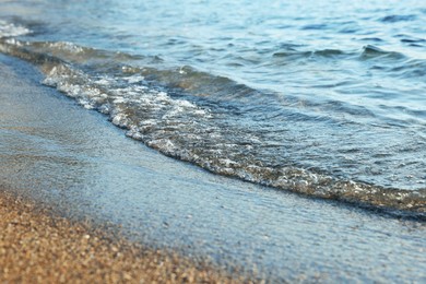 Photo of Beautiful wavy sea and sandy beach, closeup