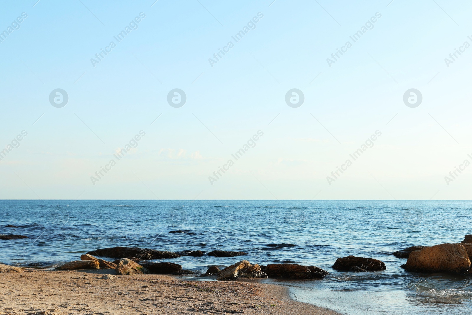 Photo of Beautiful wavy sea, stones and sandy beach