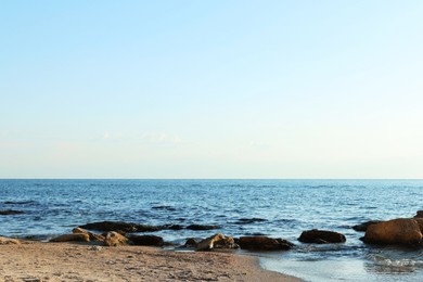 Photo of Beautiful wavy sea, stones and sandy beach