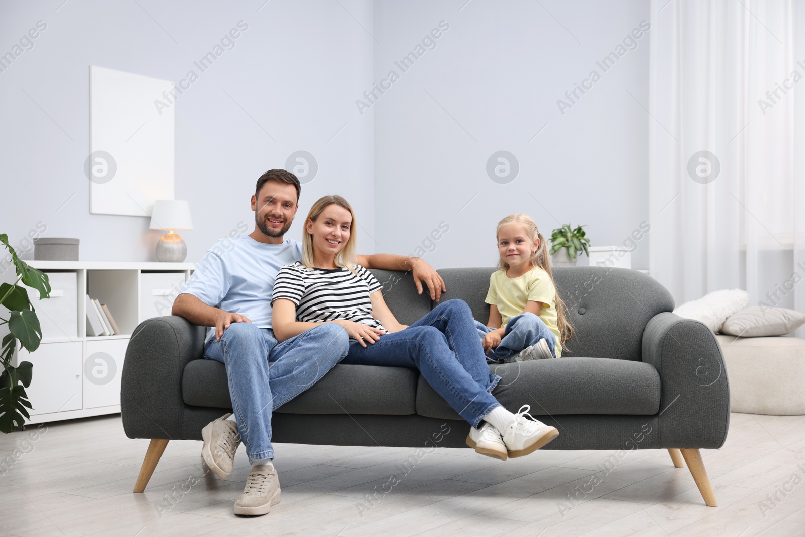 Photo of Happy family spending time together on sofa at home