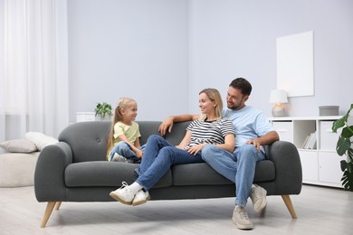 Photo of Happy family spending time together on sofa at home