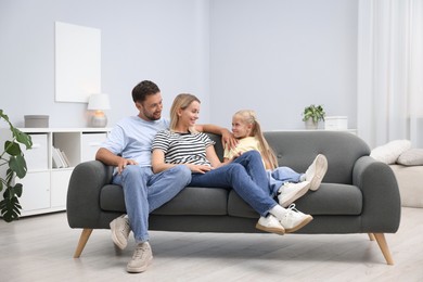 Photo of Happy family spending time together on sofa at home