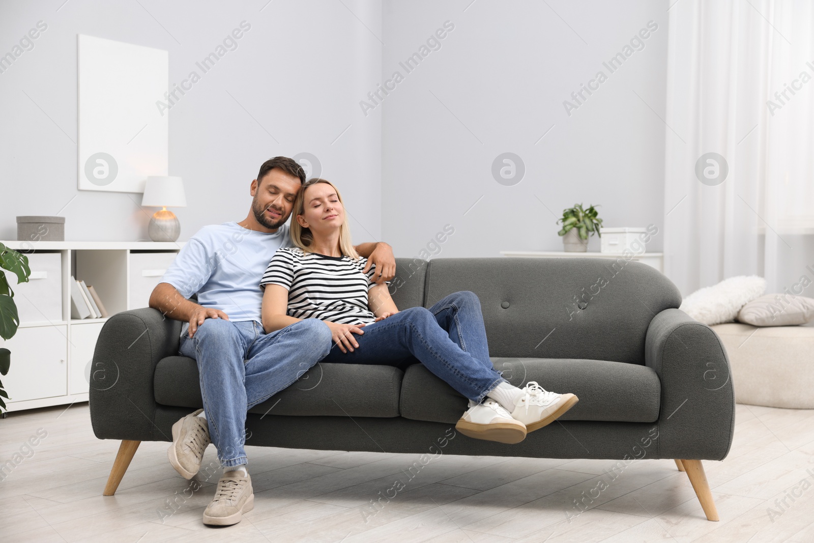 Happy family spending time together on sofa at home. Space for text Photo of Happy family spending time together on sofa at home. Space for text