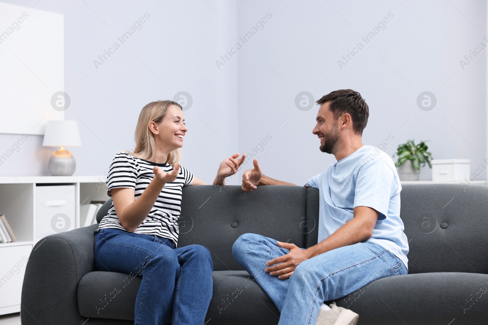 Photo of Happy couple spending time together on sofa at home
