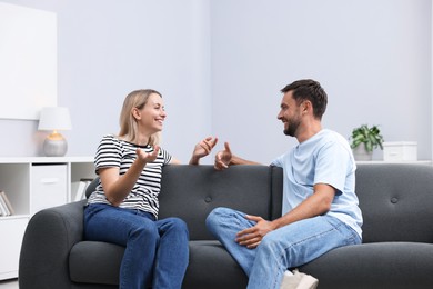 Photo of Happy couple spending time together on sofa at home