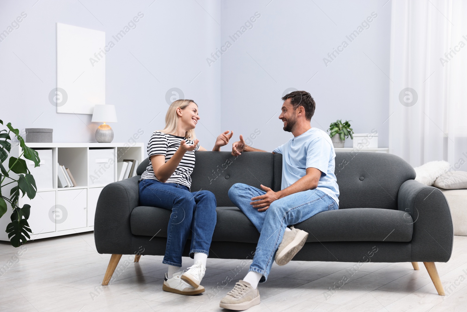 Photo of Happy couple spending time together on sofa at home
