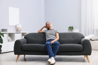 Photo of Happy woman resting on sofa at home