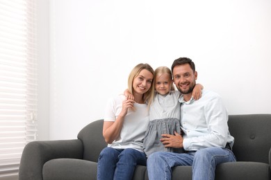 Photo of Happy family spending time together on sofa at home. Space for text