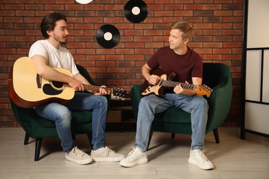 Photo of Tutor teaching man to play guitar indoors