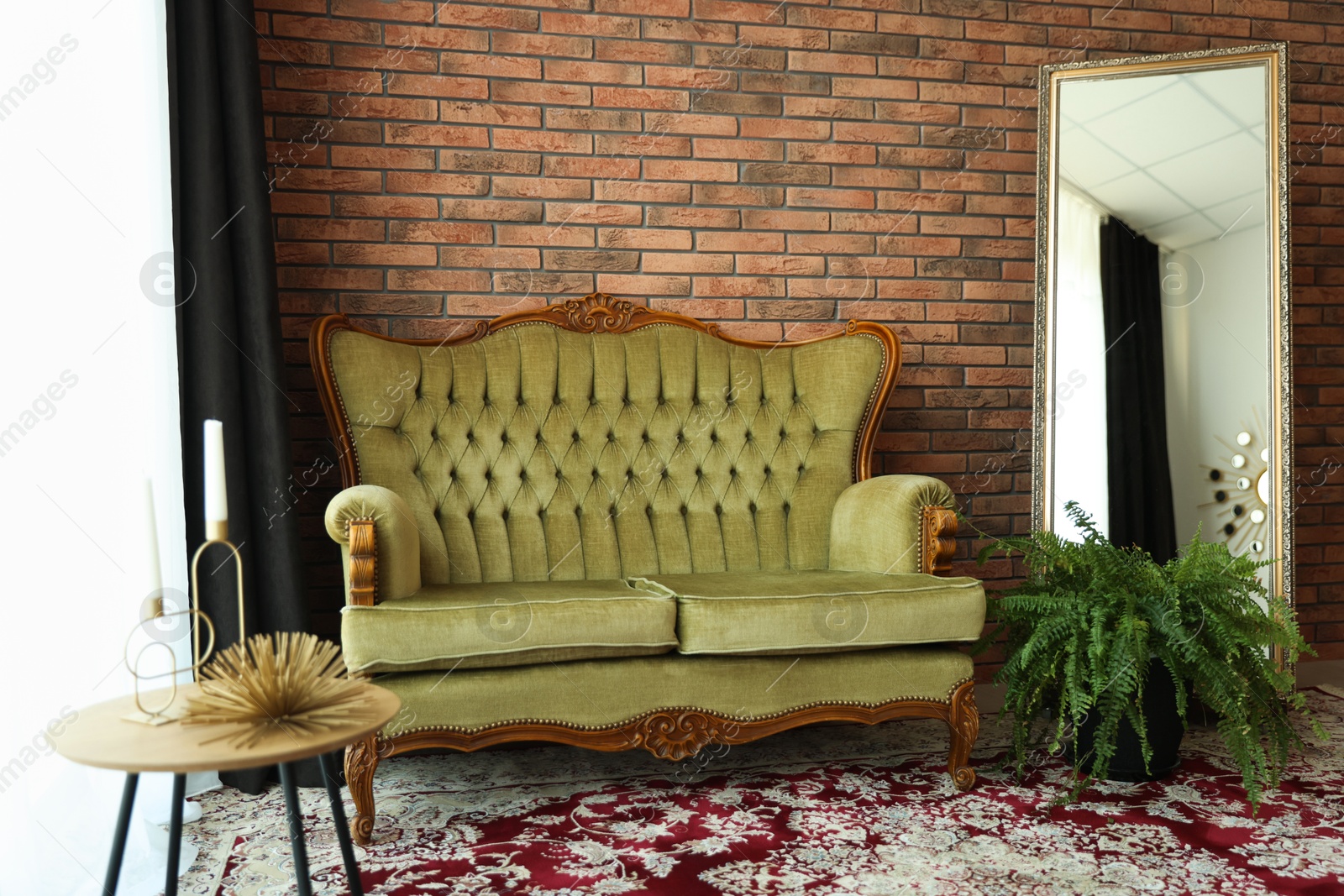 Green retro sofa, mirror, decor and houseplant in room. Interior design Photo of Green retro sofa, mirror, decor and houseplant in room. Interior design