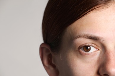 Photo of Woman with beautiful eyes on light grey background, closeup. Space for text