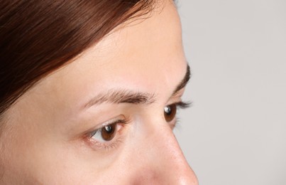 Photo of Woman with beautiful eyes on light grey background, closeup. Space for text