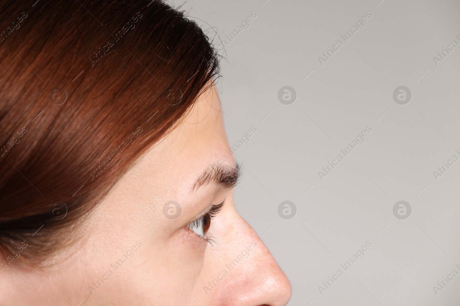 Photo of Woman with beautiful eyes on light grey background, closeup. Space for text
