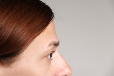 Photo of Woman with beautiful eyes on light grey background, closeup. Space for text