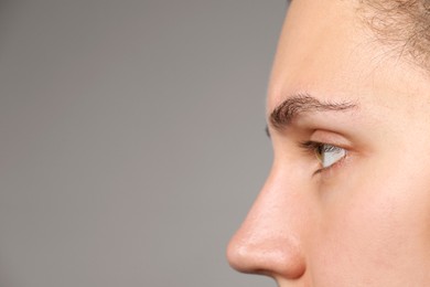 Photo of Woman with beautiful eyes on light grey background, closeup. Space for text
