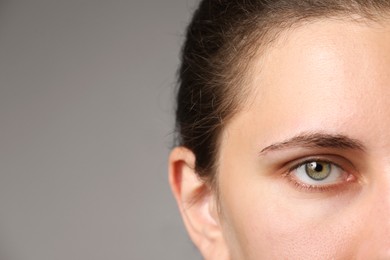 Photo of Woman with beautiful eyes on light grey background, closeup. Space for text