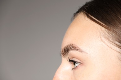 Photo of Woman with beautiful eyes on light grey background, closeup. Space for text