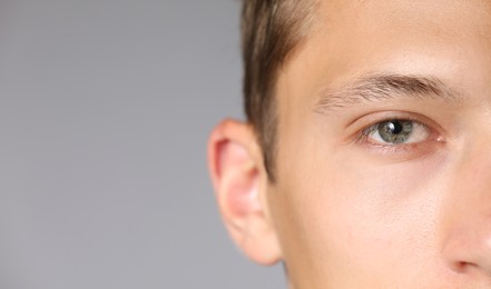 Photo of Man with beautiful eyes on light grey background, closeup. Space for text