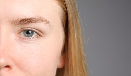 Photo of Woman with beautiful eyes on light grey background, closeup. Space for text